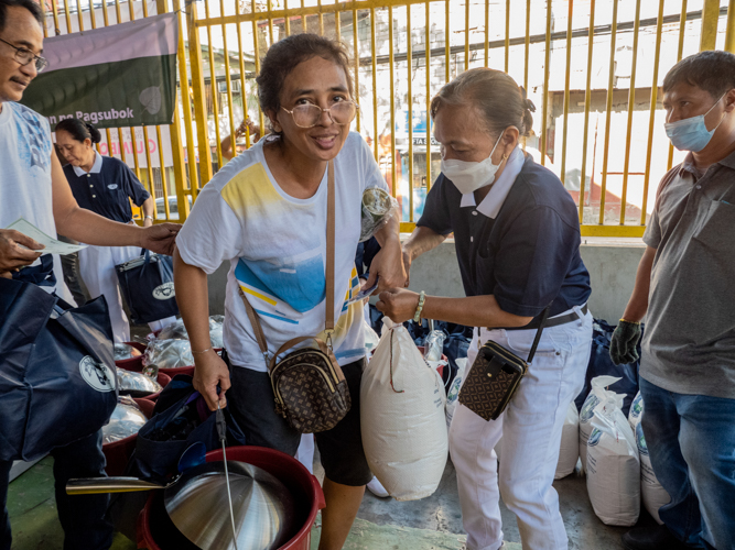 Residents claim their relief goods from Tzu Chi volunteers. 【Photo by Matt Serrano】