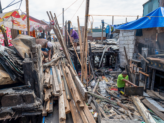 Isla Puting Bato residents try to salvage what is left of their damaged homes after the fire. 【Photo by Jeaneal Dando】