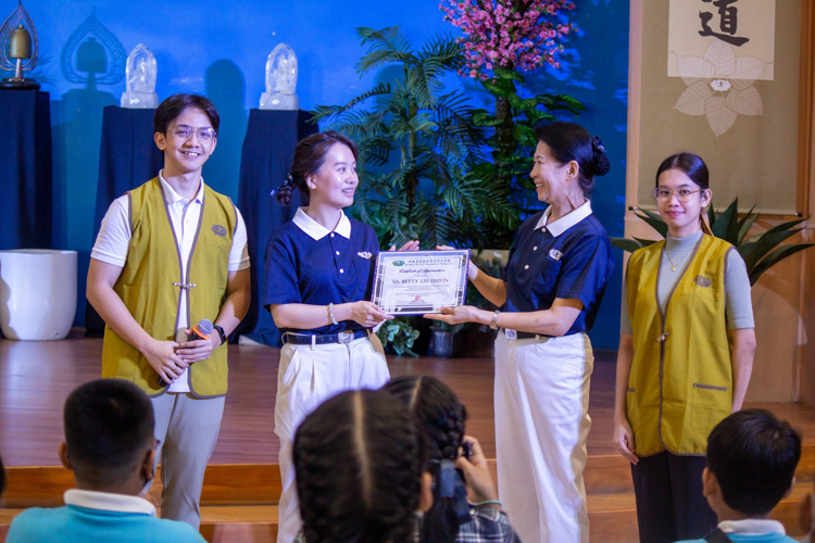 Volunteer Betty Dizon (second from left) accepts a certificate of appreciation from Tzu Chi Philippines Deputy CEO Woon Ng (second from right). 【Photo by Marella Saldonido】