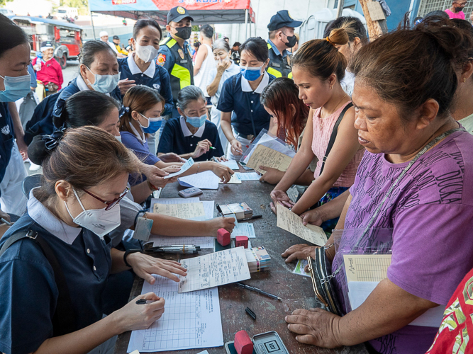 The beneficiaries line up during the distribution of claim stubs at the Leonardo Fugoso Sport Complex on April 18. 【Photo by Matt Serrano】