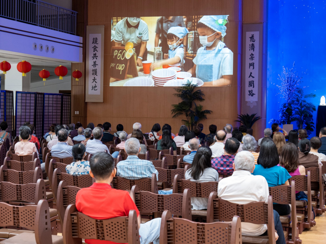 At the Jing Si Hall, guests watch videos of Tzu Chi’s milestones in 2023. 【Photo by Matt Serrano】