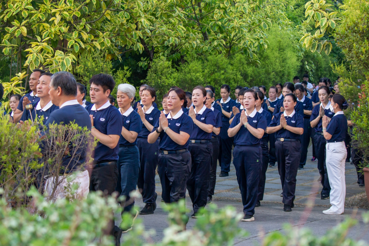 With palms together in prayer, Tzu Chi volunteers perform 3 steps and 1 bow from the garden path leading to the Jing Si Abode. 【Photo by Marella Saldonido】