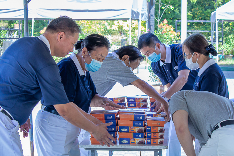 Tzu Chi volunteers prepare vegetarian lunch packs for beneficiaries to receive after claiming their 20kg rice, bag of groceries, and personal hygiene kit. 【Photo by Marella Saldonido】