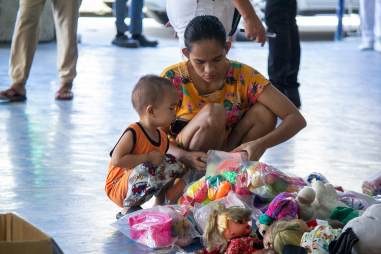A mother helps her son choose toys during the bazaar. 【Photo by Matt Serrano】