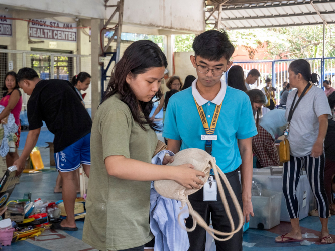 A Tzu Chi scholar assists a customer at the bazaar. 【Photo by Matt Serrano】