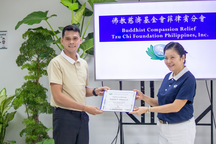 Rodolfo A. Llevarez Jr. (left) receives his RAC scholarship certificate from Tzu Chi Head of Education Committee Rosa So. 【Photo by Marella Saldonido】