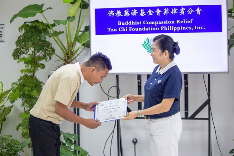 “I’m very happy to receive this opportunity to study. Through this, I can get better jobs and help my family,” said Jay Cris Domanais (left). The newly awarded RAC scholar accepted his scholarship certificate from Tzu Chi Head of Education Committee Rosa So. 【Photo by Marella Saldonido】
