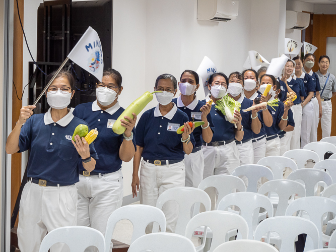 Waving flags, volunteers from Metro Manila, Bicol, Bohol Cebu, Davao, Palo, Pampanga, and Zamboanga make a lively entrance before the start of the planning session of the Tzu Chi 2023 Annual Meeting. 【Photo by Marella Saldonido】
