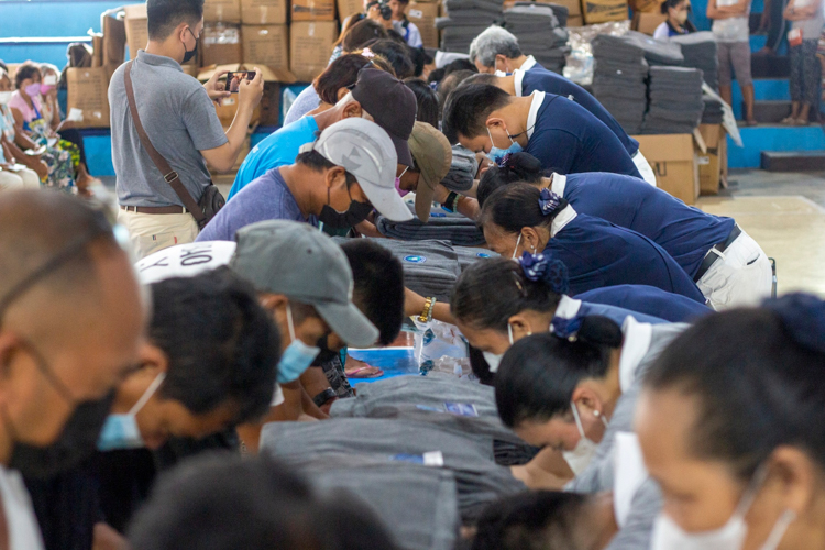 Tzu Chi volunteers and beneficiaries bow to each other in handing over of goods as a sign of gratitude. 【Photo by Matt Serrano】