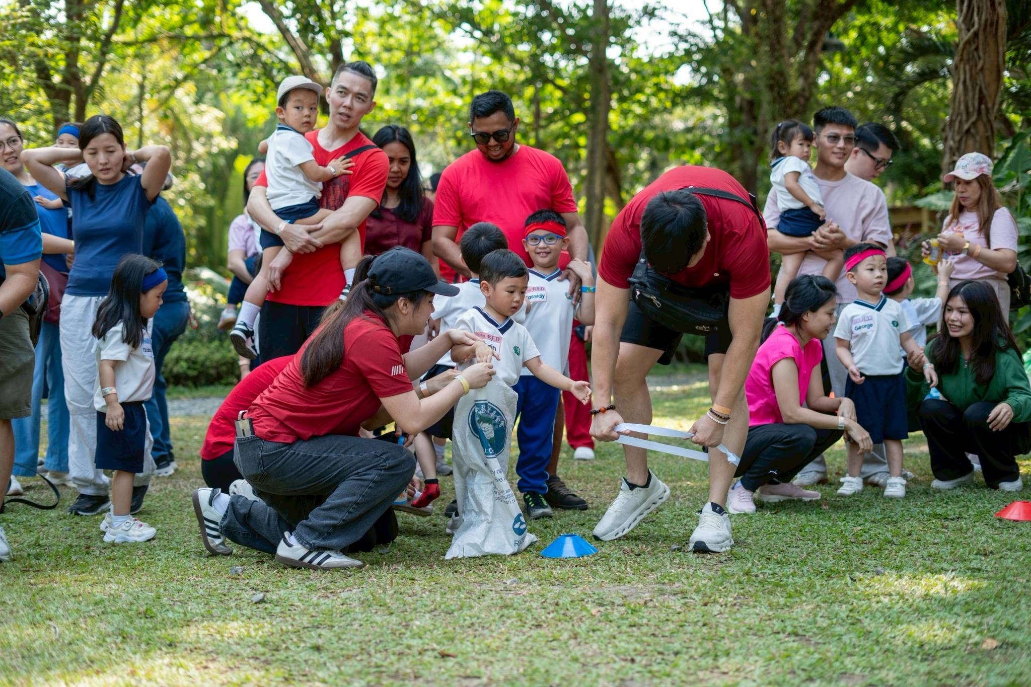With their parents’ guidance, students participate in the sack race.