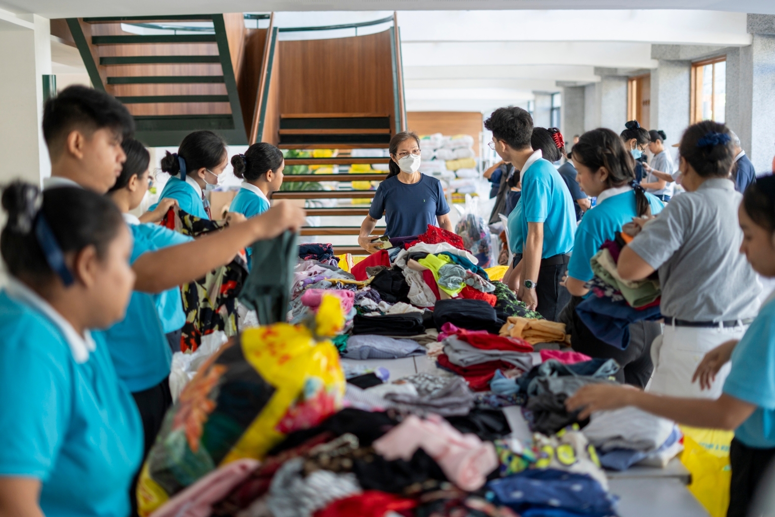 Tzu Chi volunteer Elvira Chua (center) joins Tzu Chi scholars and other volunteers in packing donated clothes for storm survivors. 