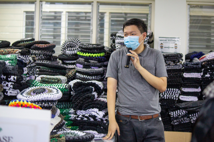 Tzu Chi Partnerships Assistant Clifford Co shows scholars seat covers made of excess sports sock materials—one of the products created by volunteers of Tzu Chi’s recycling program. 【Photo by Marella Saldonido】  