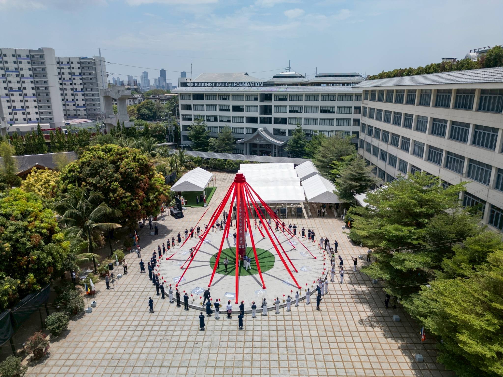 Guests encircle the groundbreaking marker where the Tzu Chi Medical Center is set to rise.