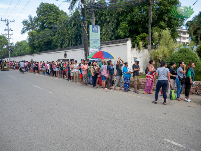 Beneficiairies are all smiles as they line up in an orderly manner to claim relief at the Sisters of Mary Girlstown in Talisay.