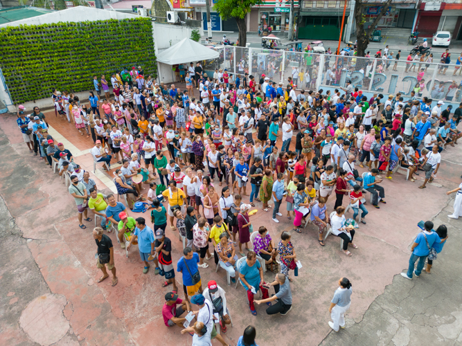 Beneficiaries line up as early as 7AM at the Concepcion Integrated School grounds in Tumana, Marikina. 