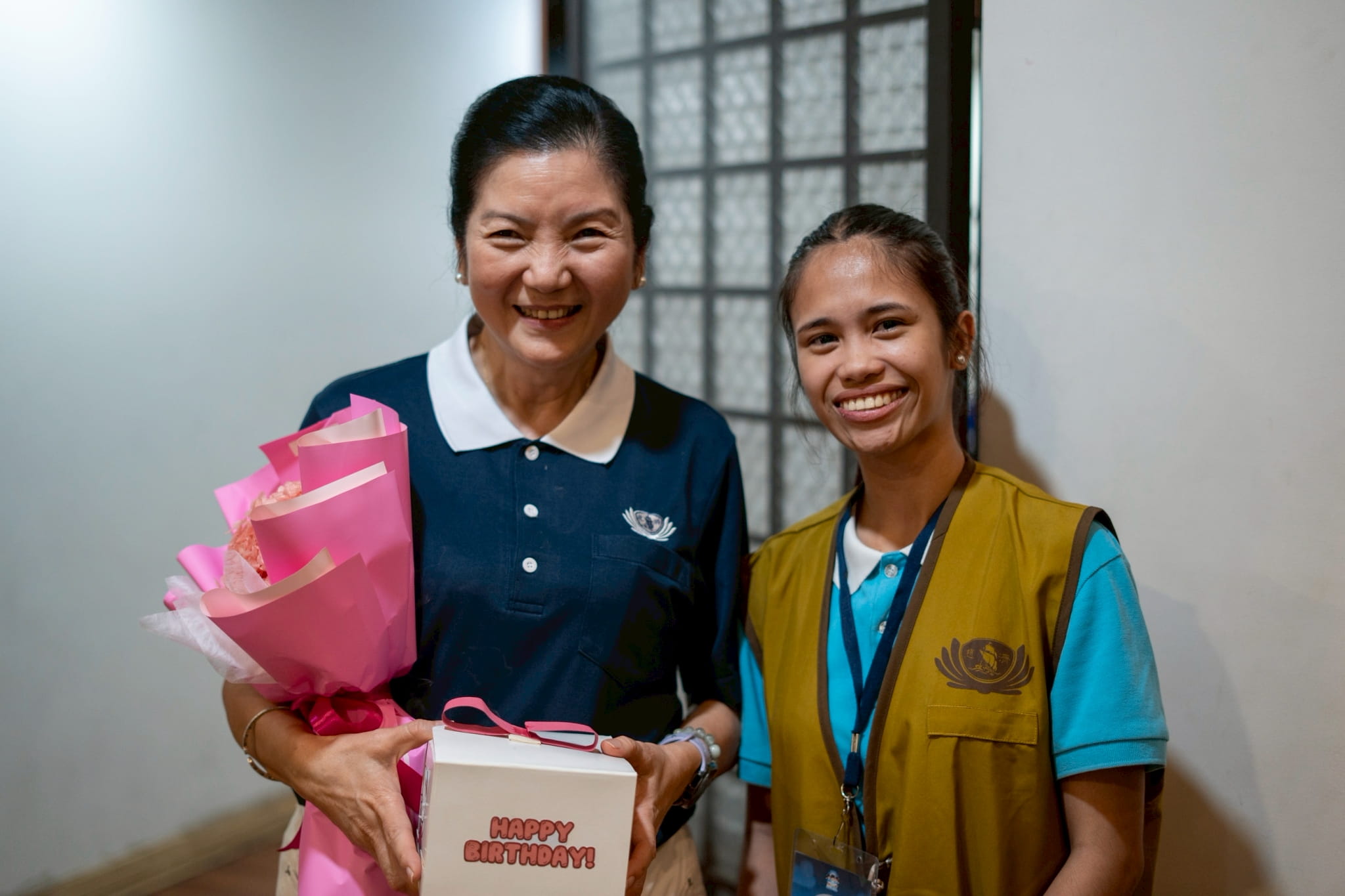 (Left) Rosa So, head volunteer of Tzu Chi’s educational and medical assistance programs, receives gifts at a surprise segment for July celebrators at the 2026 Tzu Chi Scholars’ Camp. Joining her is camp head Heart Baquilar. 