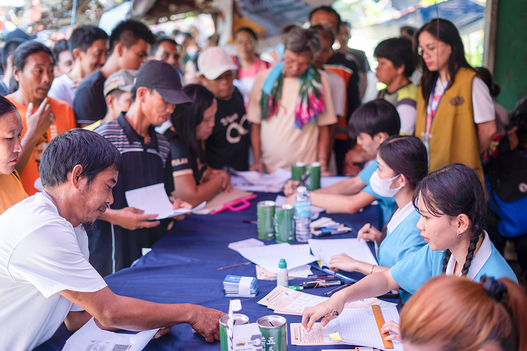 At the registration area, Tzu Chi scholars prepare to assist households in a distribution of claim stubs. 