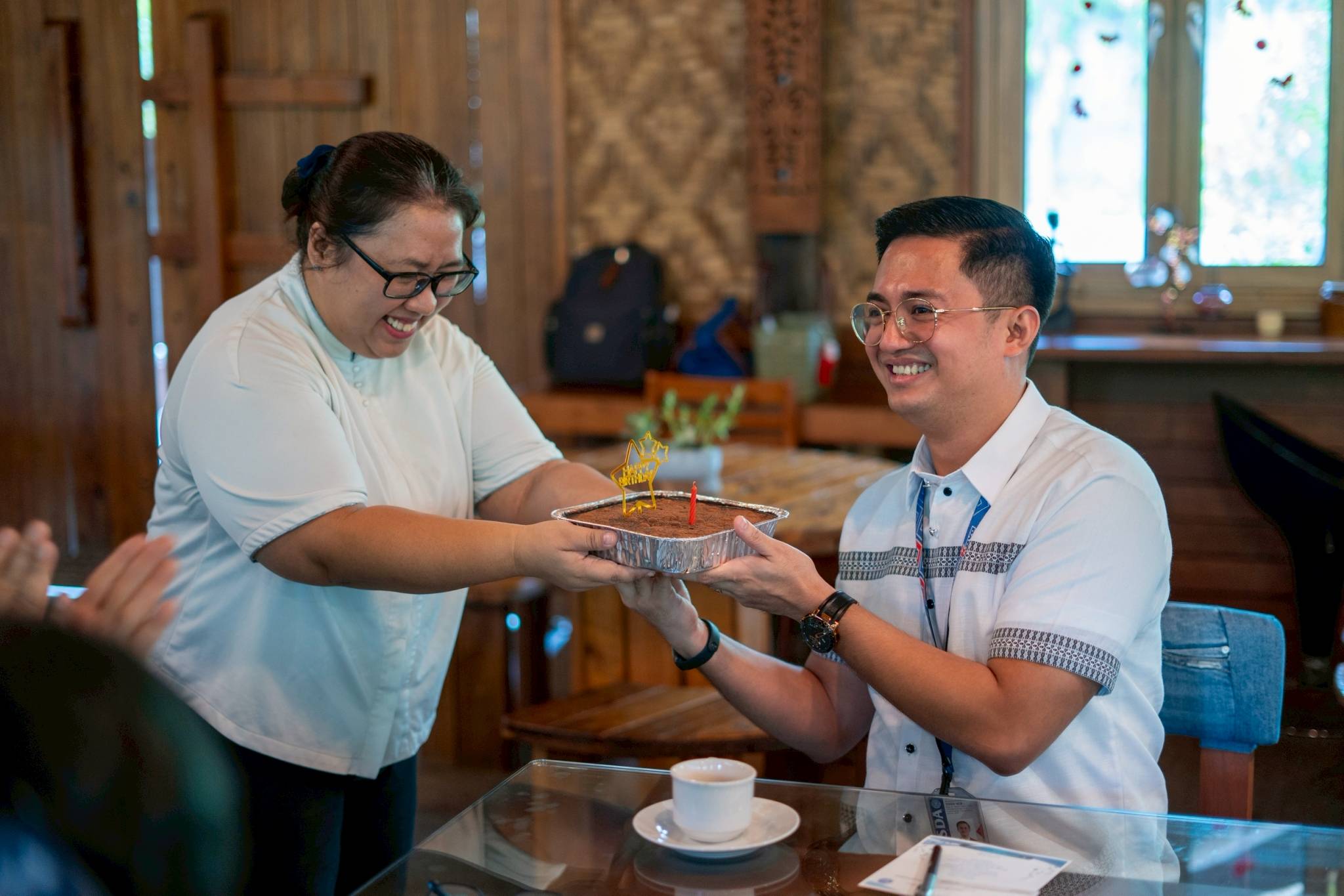 Tzu Chi Technical-Vocational Supervisor and Liaison Officer Elizabeth Auste surprises TESDA Manila District Director Paul John Ramos with a cake for his belated birthday. 