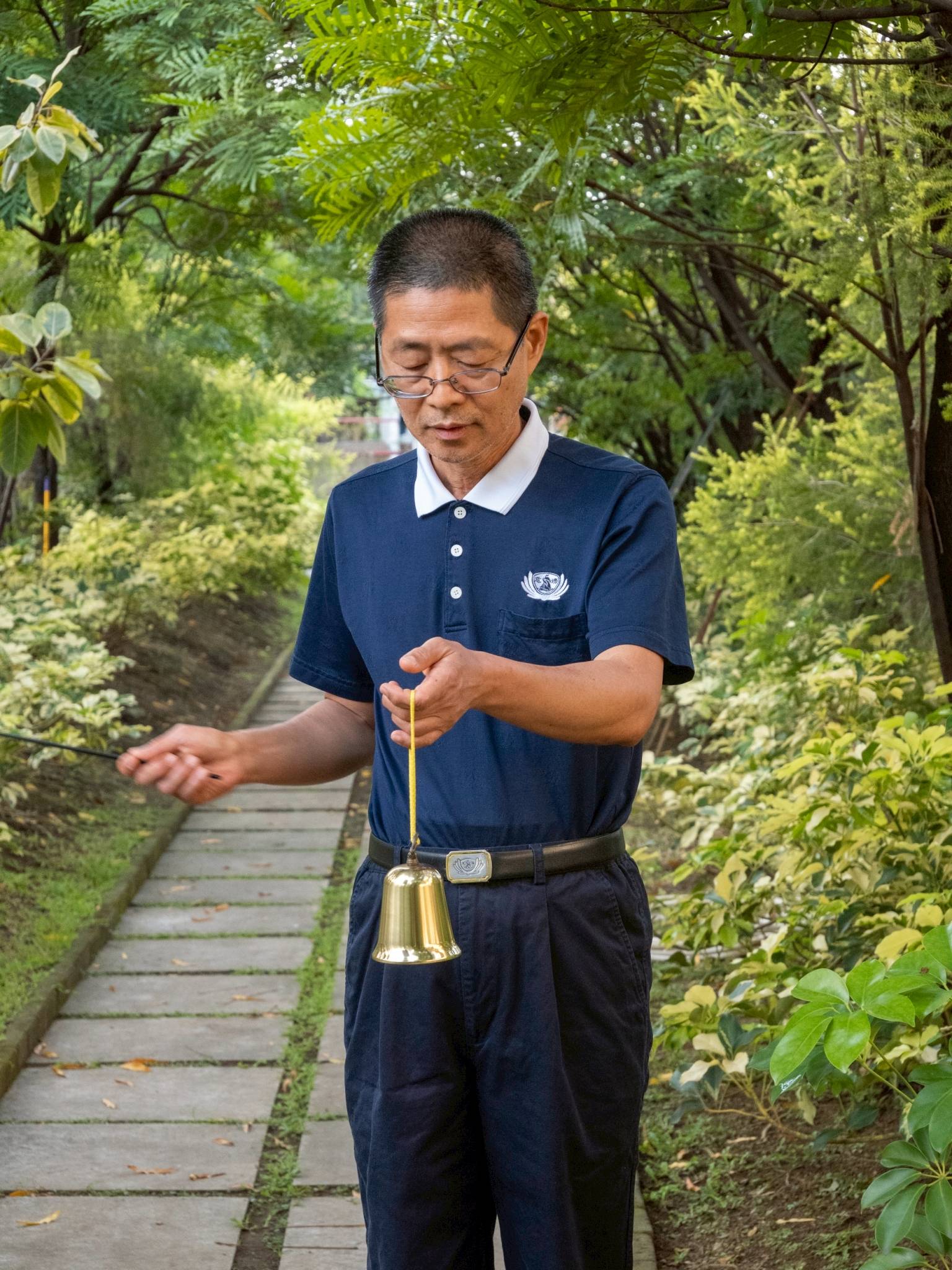 A Tzu Chi volunteer rings the bell, guiding participants through meditation.