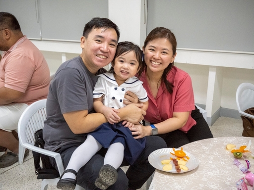 Joyous parents pose with their daughter during the Mid-Autumn Festival celebration.