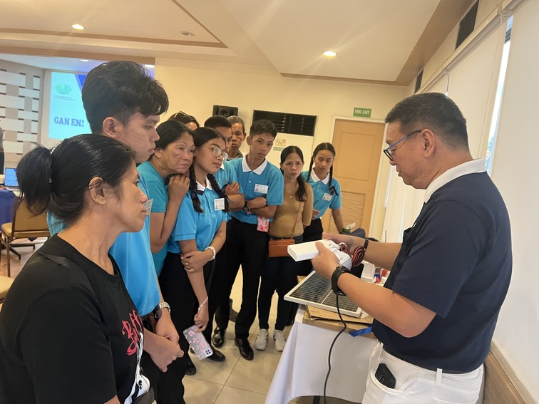 Tzu Chi Zamboanga OIC and Deputy CEO Dr. Anton Mari Lim (right) instructs scholars and their parents on how to use the solar panels. 