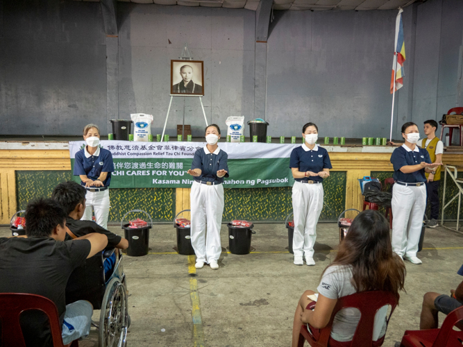 Tzu Chi volunteers did the sign language of “One Family” for the fire victims.