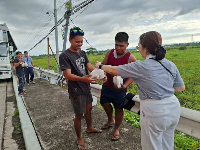 Tzu Chi Bicol volunteers hand out hot meals to stranded truck drivers in Pili, Camarines Sur.