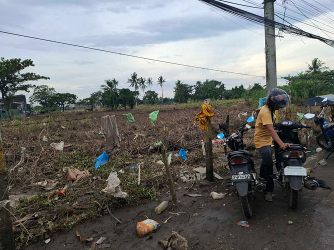 Random pieces of trash left by the fierce winds of Typhoon Kristine lay by the entrance of a still-flooded Barangay Sabang in Naga City.