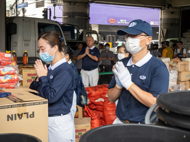 Tzu Chi volunteers join the prayer before the relief distribution.