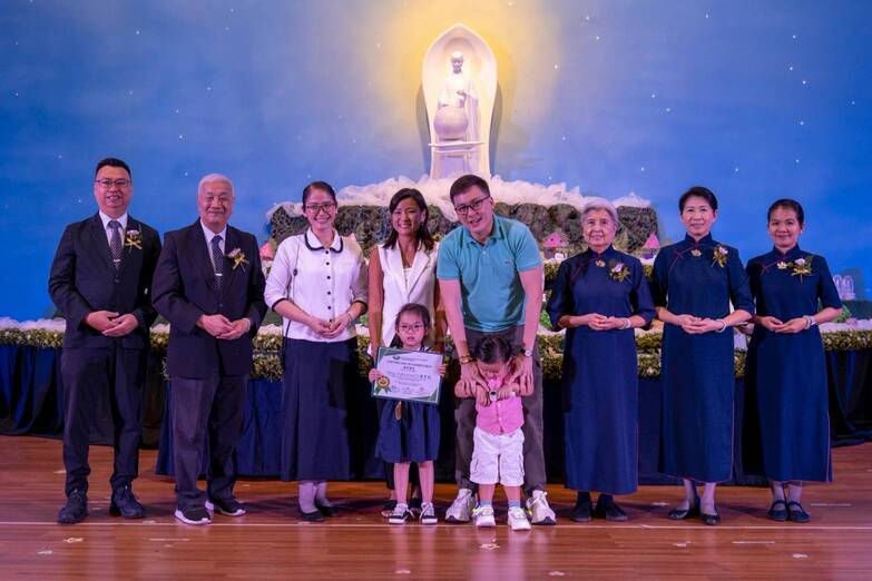 Jenny and Ian Cheng (fourth and fifth from left) accompany daughter Sofie as she receives her certificate.