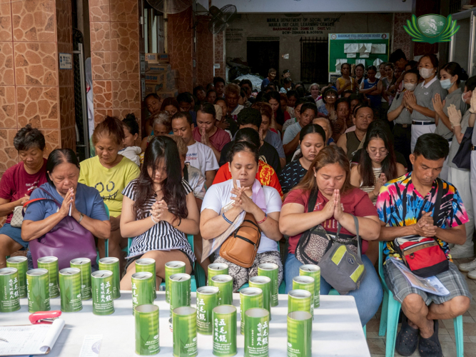 Beneficiaries put their palms together in prayer.