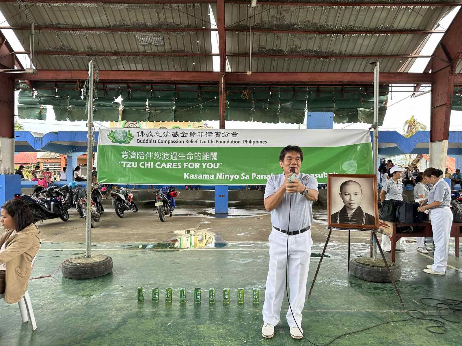 Tzu Chi volunteer Norman Binalla explains the importance of the Tzu Chi coin can to residents of Viga. 