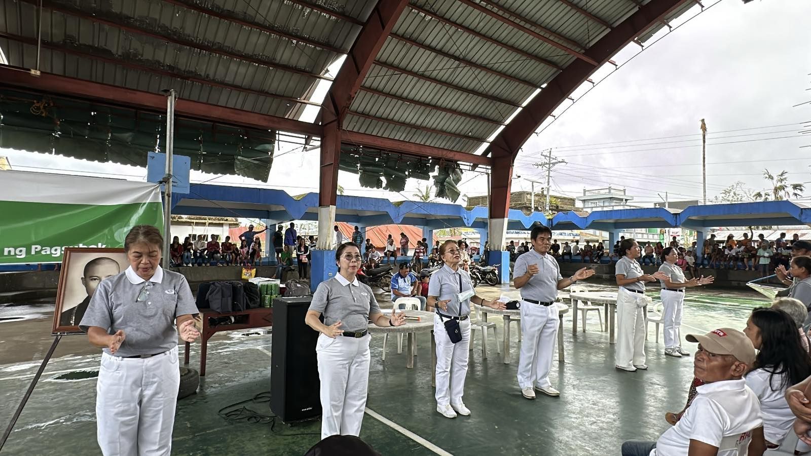 Volunteers lead residents in Viga to a signed Tzu Chi song. 