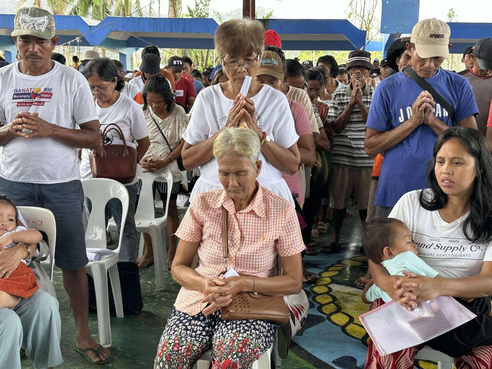 Residents in Viga spend a moment in prayer for the blessings of compassion and relief from Tzu Chi volunteers. 