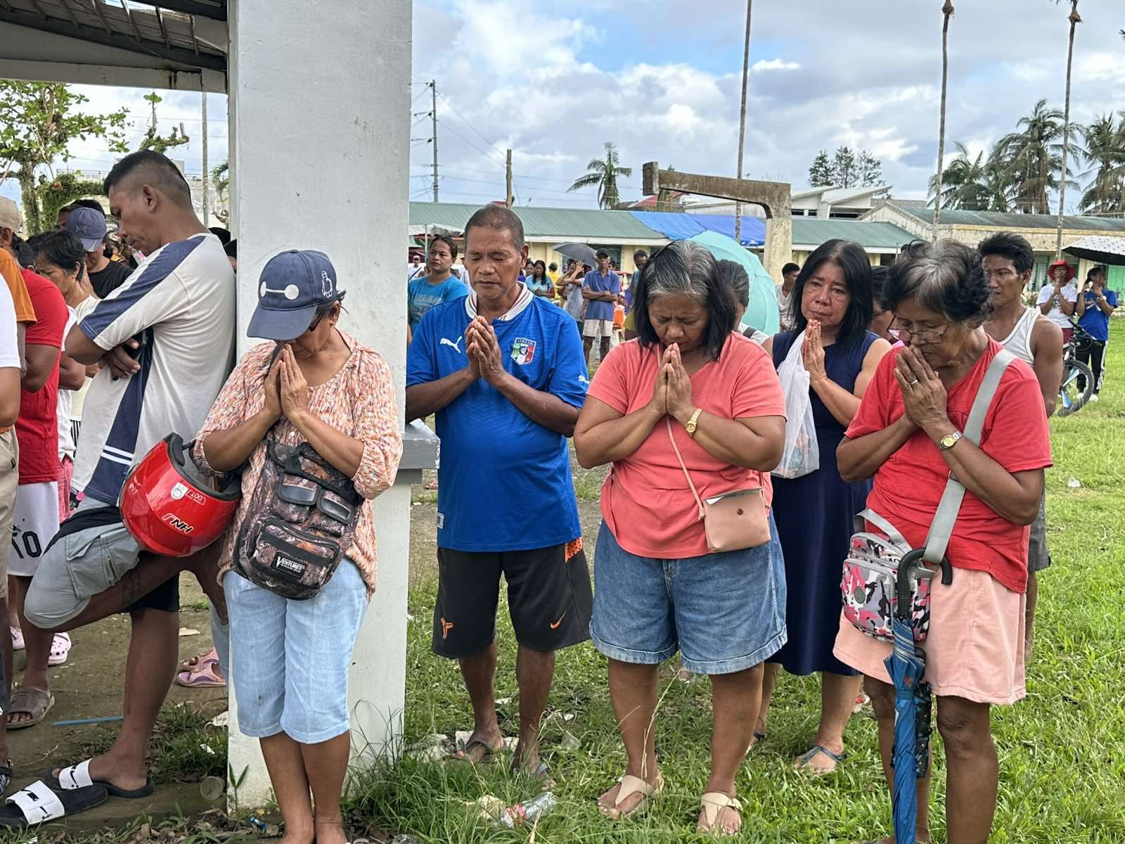 Viga beneficiaries clasp their hands in prayer. 