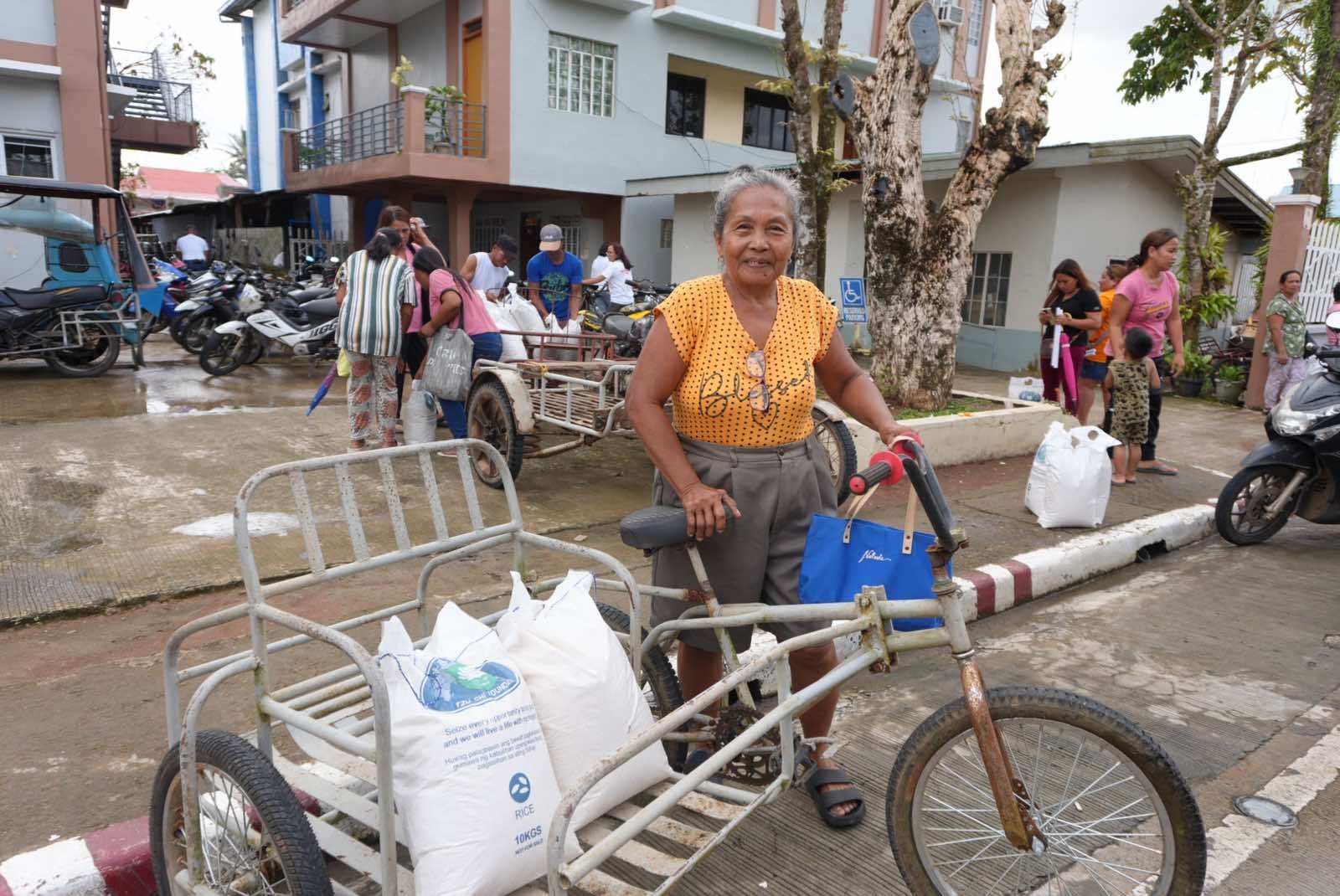 With her 10-kg sacks of rice on her pedicab, a woman from Panganiban is ready to go home. 