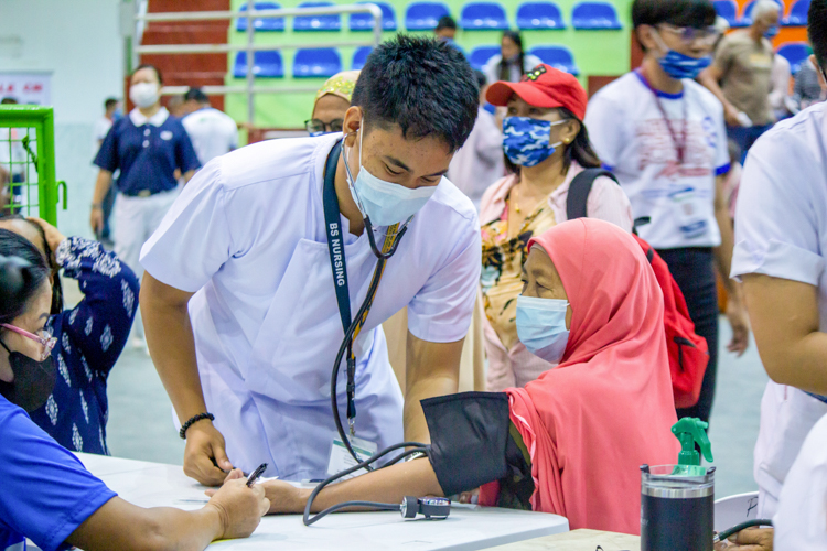 A student nurse from Sultan Kudarat State University monitors the patient’s blood pressure. 【Photo by Marella Saldonido】