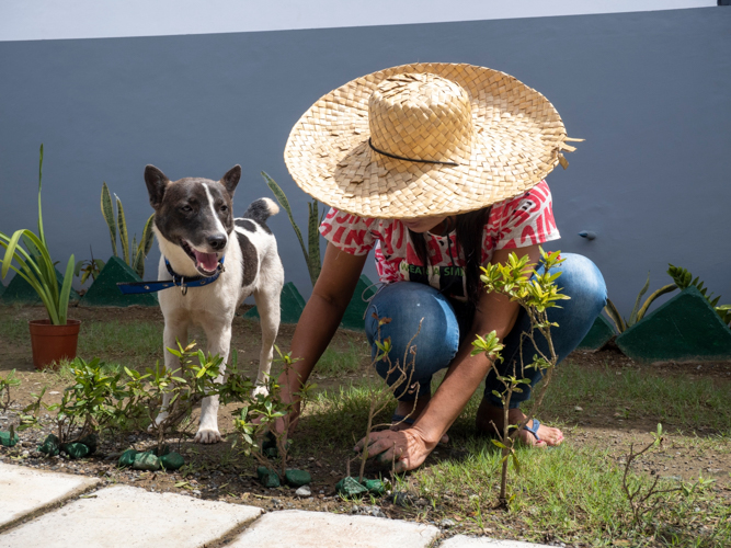 A resident at the village, alongside her loving pet, prepares her garden for the turnover.