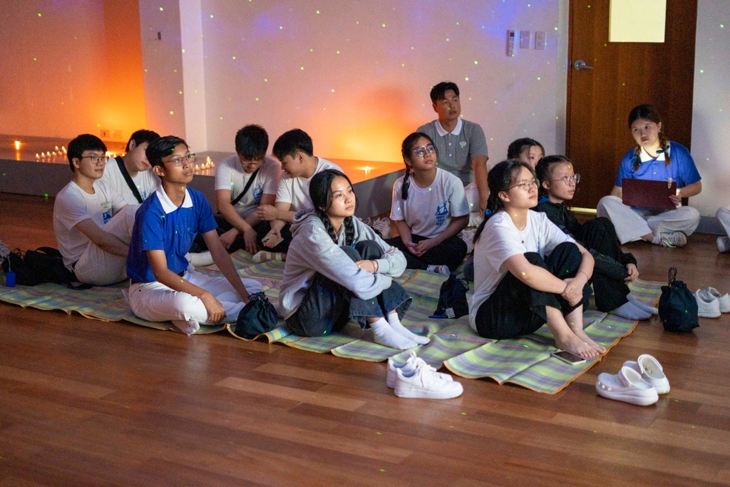 During a highly anticipated “Starry Night” activity at camp, young volunteers watch a video of Dharma Master Cheng Yen sharing lessons on volunteerism.