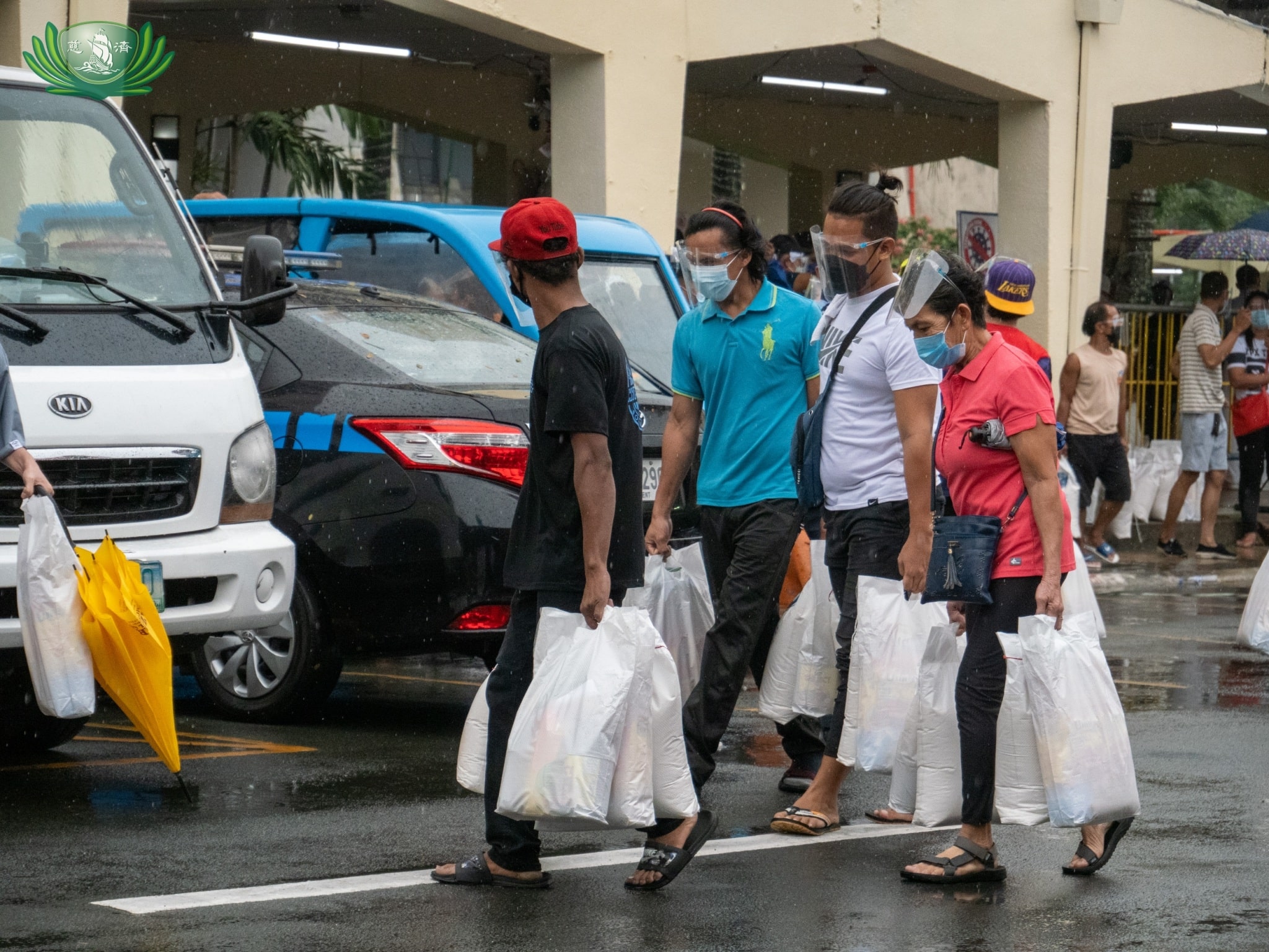 Beneficiaries leave Quezon City Hall grounds with their relief goods. 【Photo by Daniel Lazar】