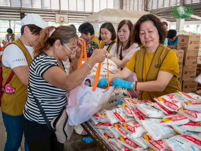 Cebu volunteers hand out essential supplies such as sugar, milk, and coffee to beneficiaries.