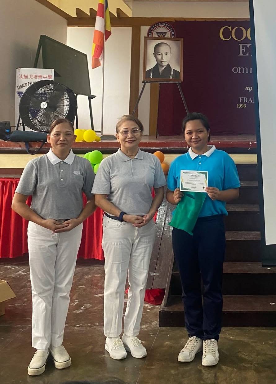 In recognition of her outstanding community service as a Tzu Chi scholar, Patricia Paula Briz (right) was presented with an award by Tzu Chi Bicol volunteers Analisa Amaranto (left) and Juvy Binalla.