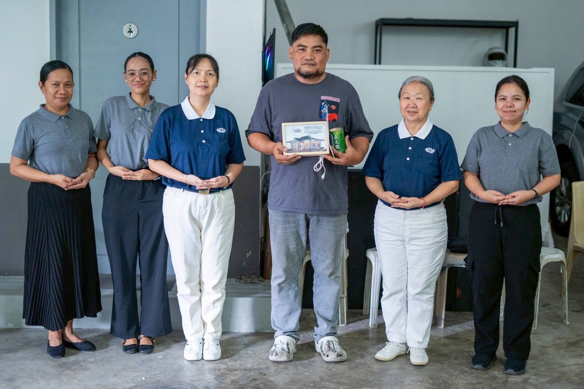 Tzu Chi representatives and Mechel Banga  (fourth from left) gather for a group photo, celebrating the end of his long medical journey and the hope of a brighter future as a new father.