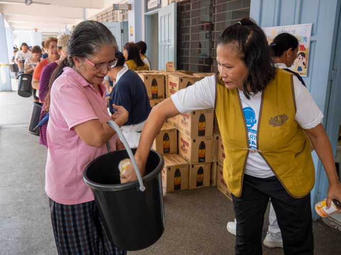 Veronica Soriano (right) helps in distributing relief items.