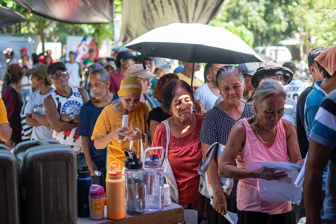 Families from Butulan, Jose Abad Santos, patiently wait in line to receive their relief claim stub.