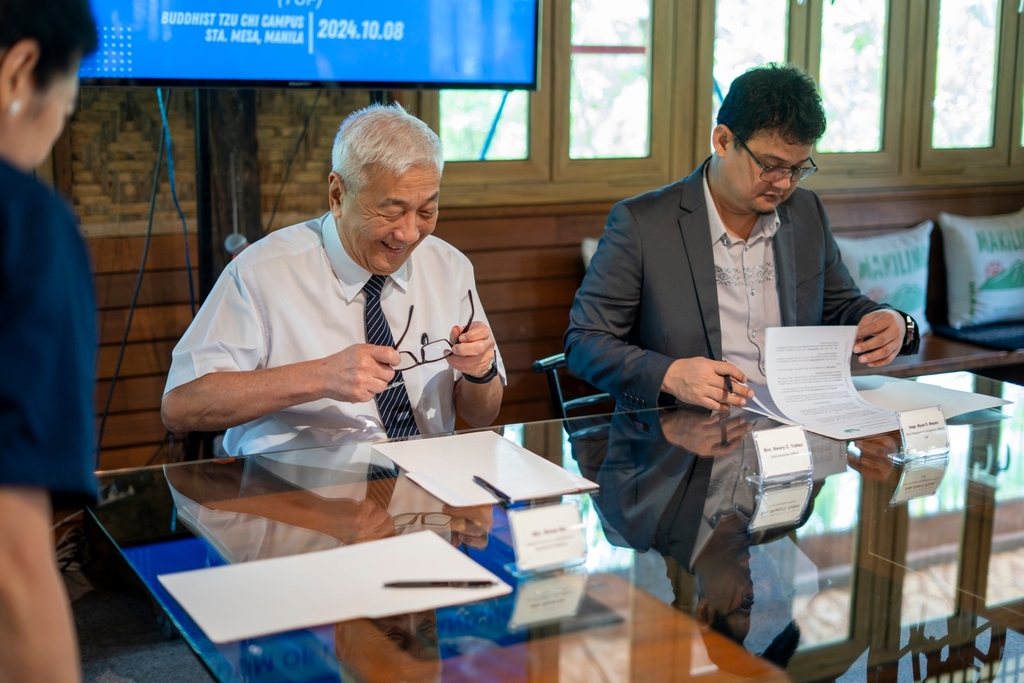 Tzu Chi Foundation Philippines CEO Henry Yuñez (left) and TUP Vice President for Academic Affairs Engineer Ryan Reyes read the Memorandum of Understanding.