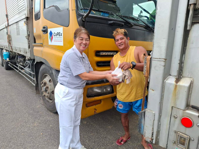 Tzu Chi Bicol volunteers hand out hot meals to stranded truck drivers in Pili, Camarines Sur.