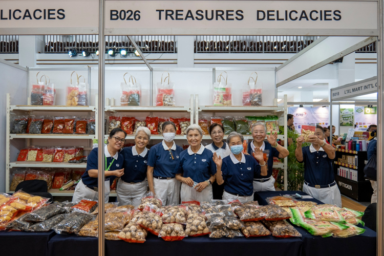 Tzu Chi Philippines’ first CEO Linda Chua helps man Treasures Delicacies, a booth selling vegetarian ingredients. 