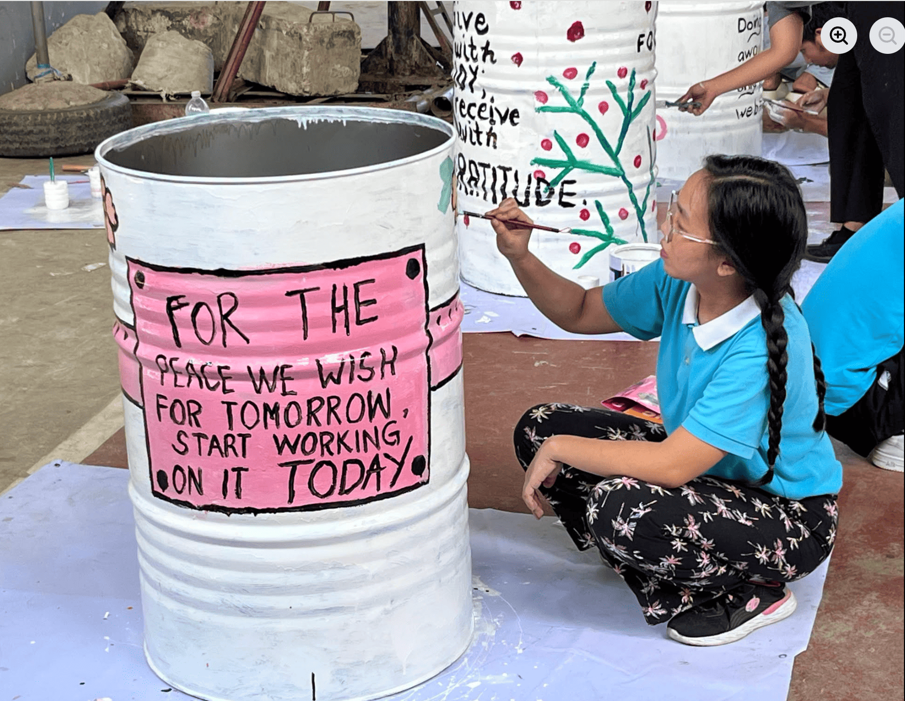 A Tzu Chi Cebu scholar paints an inspiring message on an industrial steel drum donated to Barangay Danglag / Photo courtesy of Tzu Chi Cebu.