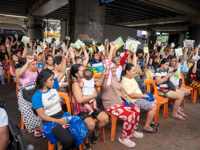 Beneficiaries happily raise their stubs after expressing their gratitude.